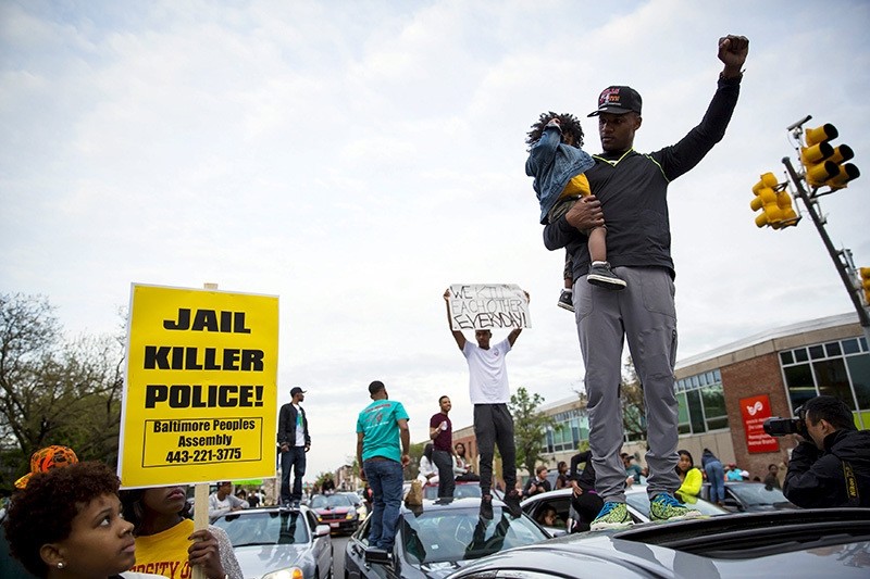 Demonstrators stand on top of vehicles at the intersection of North Avenue and Pennsylvania Avenue in Baltimore, Maryland May 1, 2015. (Reuters Photo)