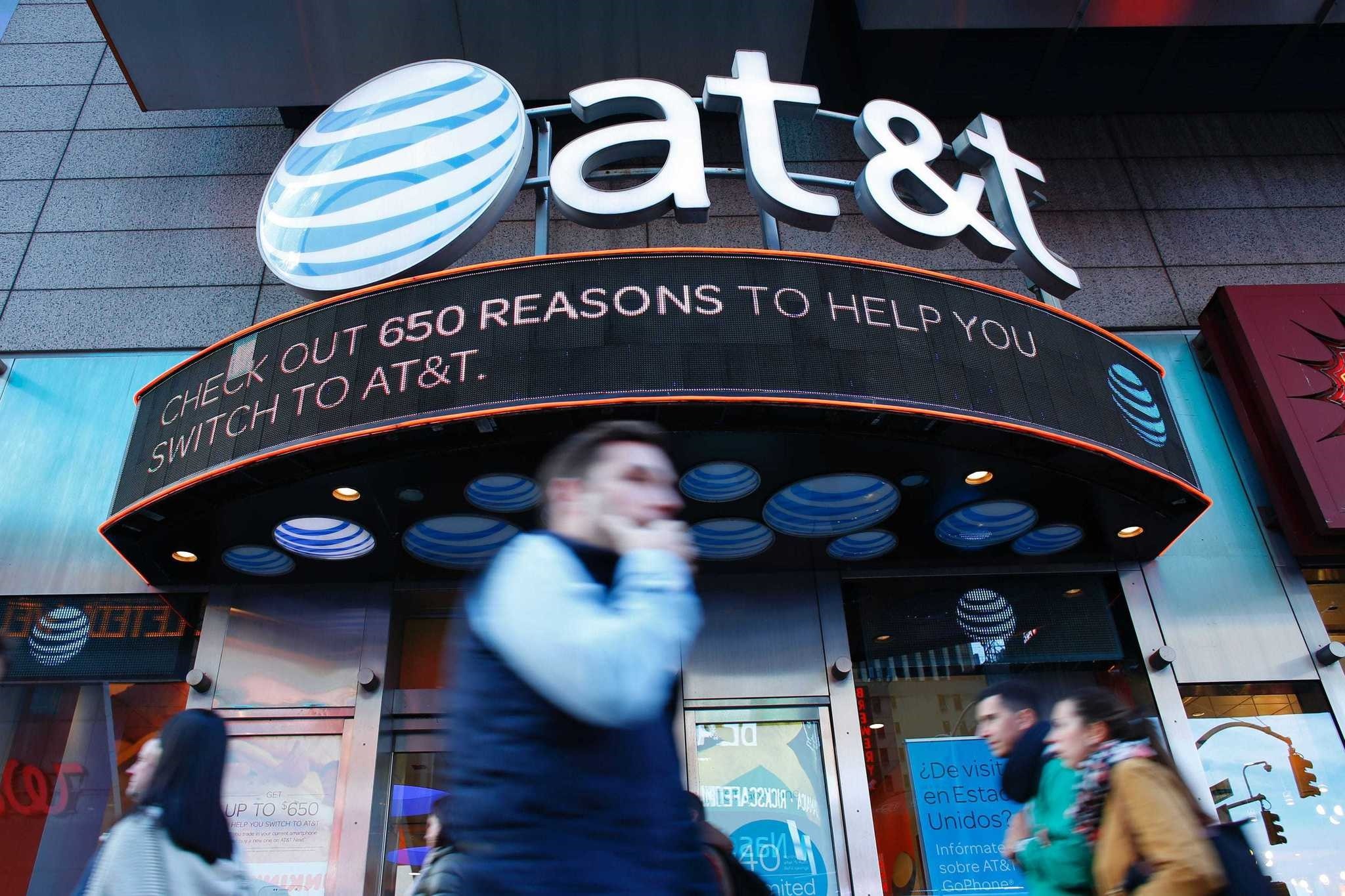People walk past an AT&T store in New York.