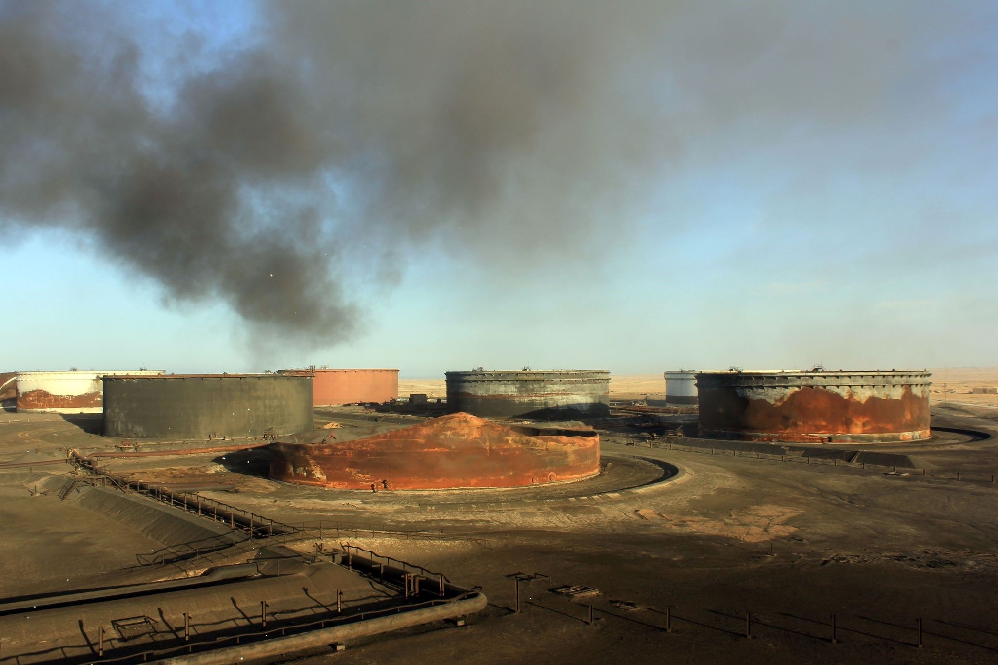 This file photo taken on January 8, 2016 shows smoke billowing from a petroleum storage tank after a fire was extinguished following fighting at Al-Sidra oil terminal. (AFP Photo)
