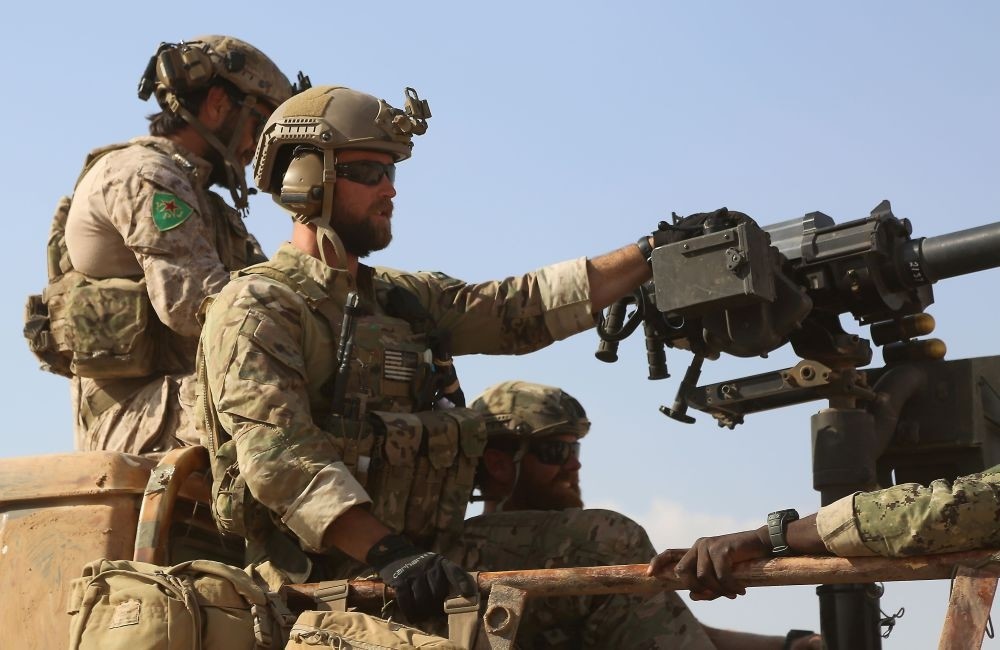 Armed U.S. special soldiers, wearing insignia resembling those of the Kurdish Peopleu2019s Protection Units (YPG), are riding in the back of a pickup truck in the village of Fatisah in the north Syrian province of Raqqa on May 25, 2016.