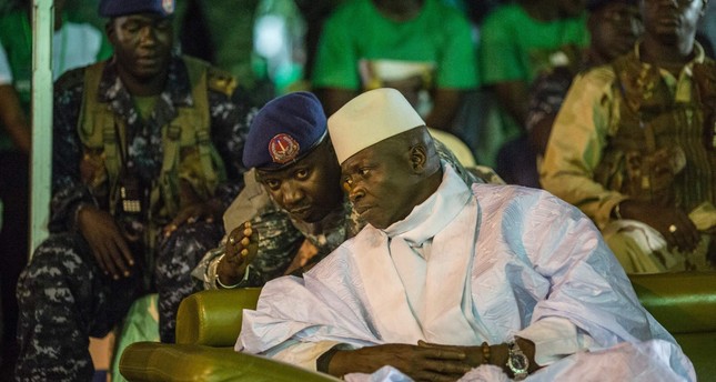 Gambian President Yahya Jammeh listening to one of his aides in Banjul, during the closing rally of the electoral campaign. (AFP Photo)