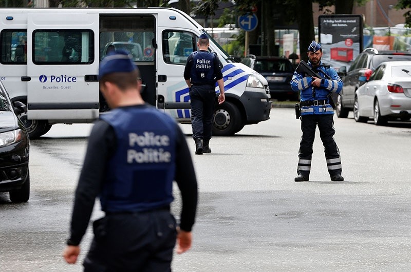 Belgian police officers stand guard near an apartment building during the reconstruction of the recent attacks, in the Brussels district of Etterbeek, Belgium, June 17, 2016. (Reuters)