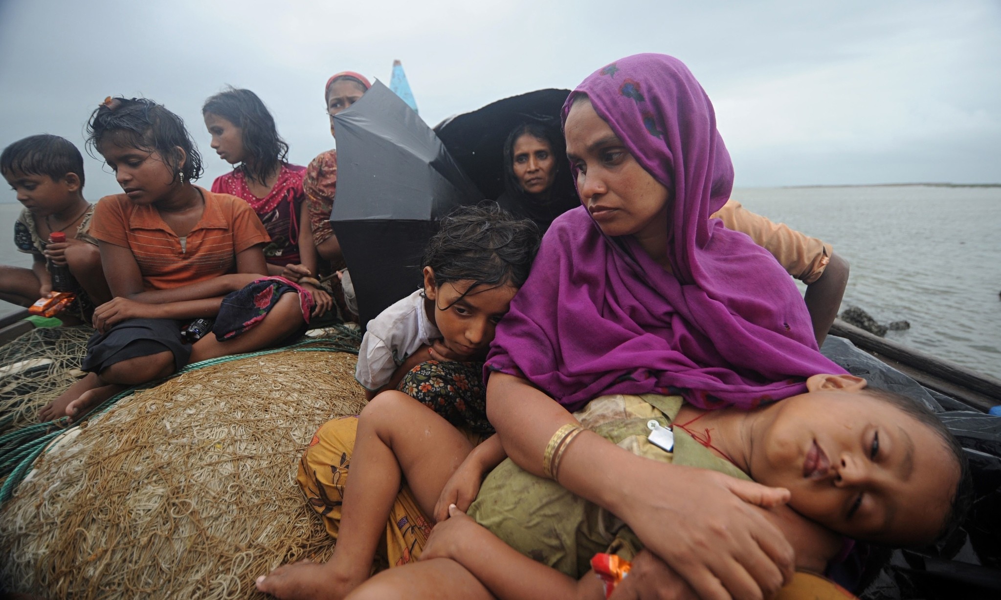 Rohingya Muslim women and children sit in a boat after they were intercepted by the Bangladesh Border Guard (BGB) members in Teknaf, Bangladesh.