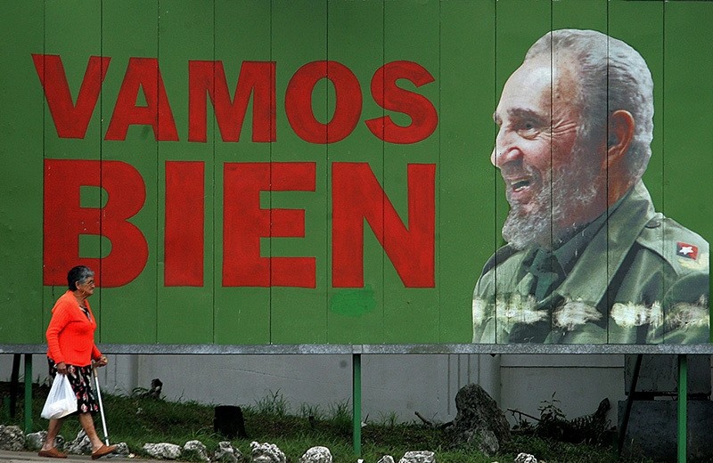 This file photo taken on November 21, 2006 shows a woman walking past a bilboard of Cuban President Fidel Castro ('We're On The Good Track') 21 November 2006, in Havana. (AFP Photo)