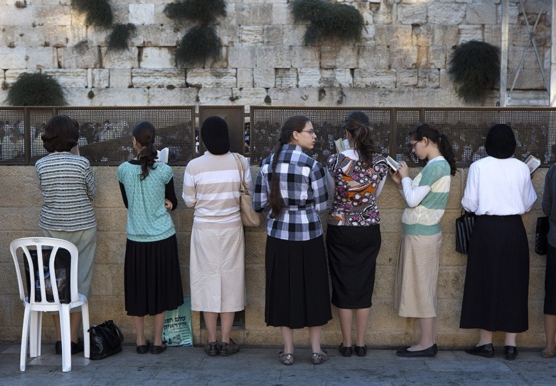 Orthodox Jewish women reading from prayer books behind a large crowd of women packing the women's section of the Western Wall in Jerusalem's Old City (EPA Photo)