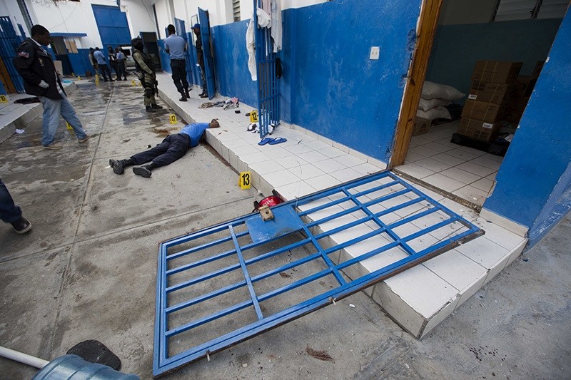 A guard lies dead inside the Civil Prison after a jail break in the coastal town of Arcahaie, Haiti, Saturday, Oct. 22, 2016. Over 100 inmates escaped after they overpowered guards who were escorting them to a bathing area. (AP Photo)