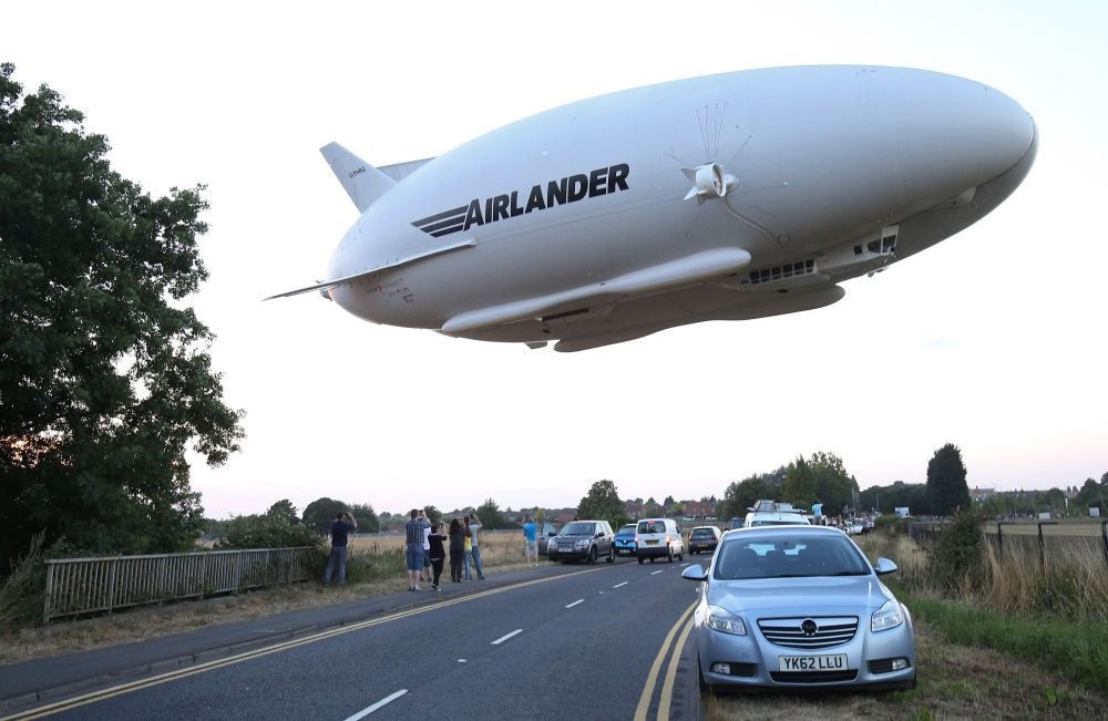 The Hybrid Air Vehicles HAV 304 Airlander 10 hybrid airship is seen in the air over a road on its maiden flight from Cardington Airfield near Bedford, north of London.