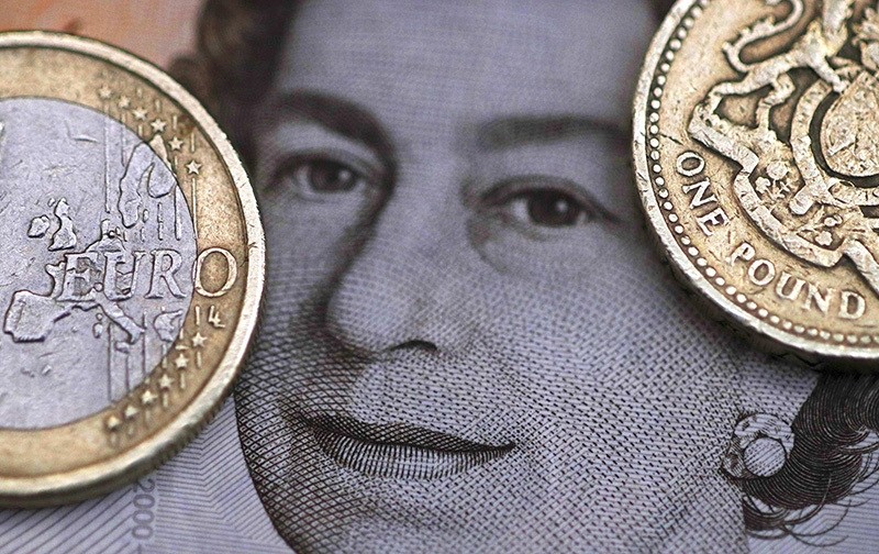 A two Euro coin is pictured next to a one Pound coin on top of a portrait of Britain's Queen Elizabeth in this file photo illustration shot March 16, 2016. (Reuters Photo)