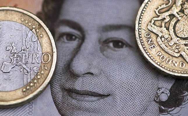 A two Euro coin is pictured next to a one Pound coin on top of a portrait of Britain's Queen Elizabeth in this file photo illustration shot March 16, 2016. (Reuters Photo)