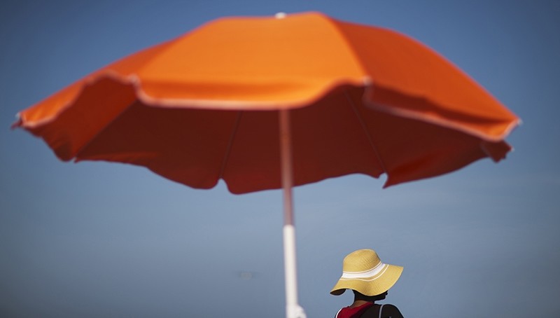 In this Tuesday, June 16, 2015, file photo, a woman sits next to an umbrella while looking out toward the ocean in Folly Beach, S.C. (AP Photo)