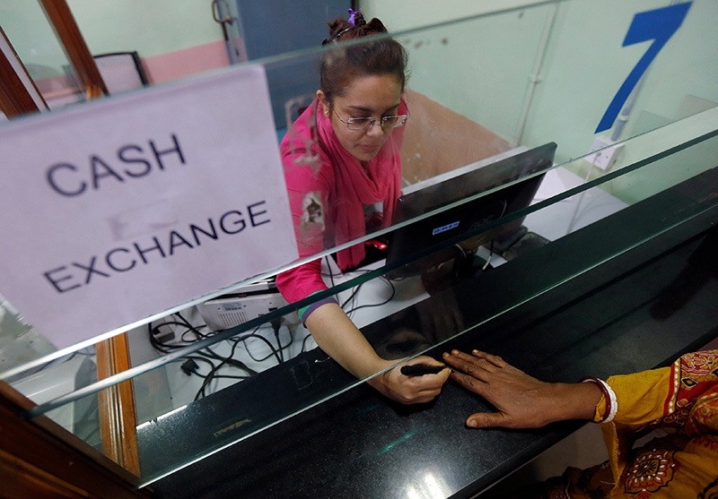 A bank employee puts indelible ink mark to a customeru2019s finger inside a bank in Kolkata, India, November 23, 2016. (Reuters Photo)