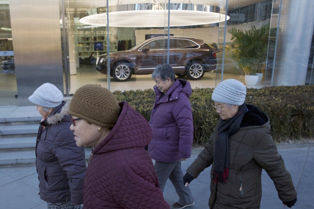 Elderly women enjoy their daily walk outside the Bentley Motors showroom in Beijing.