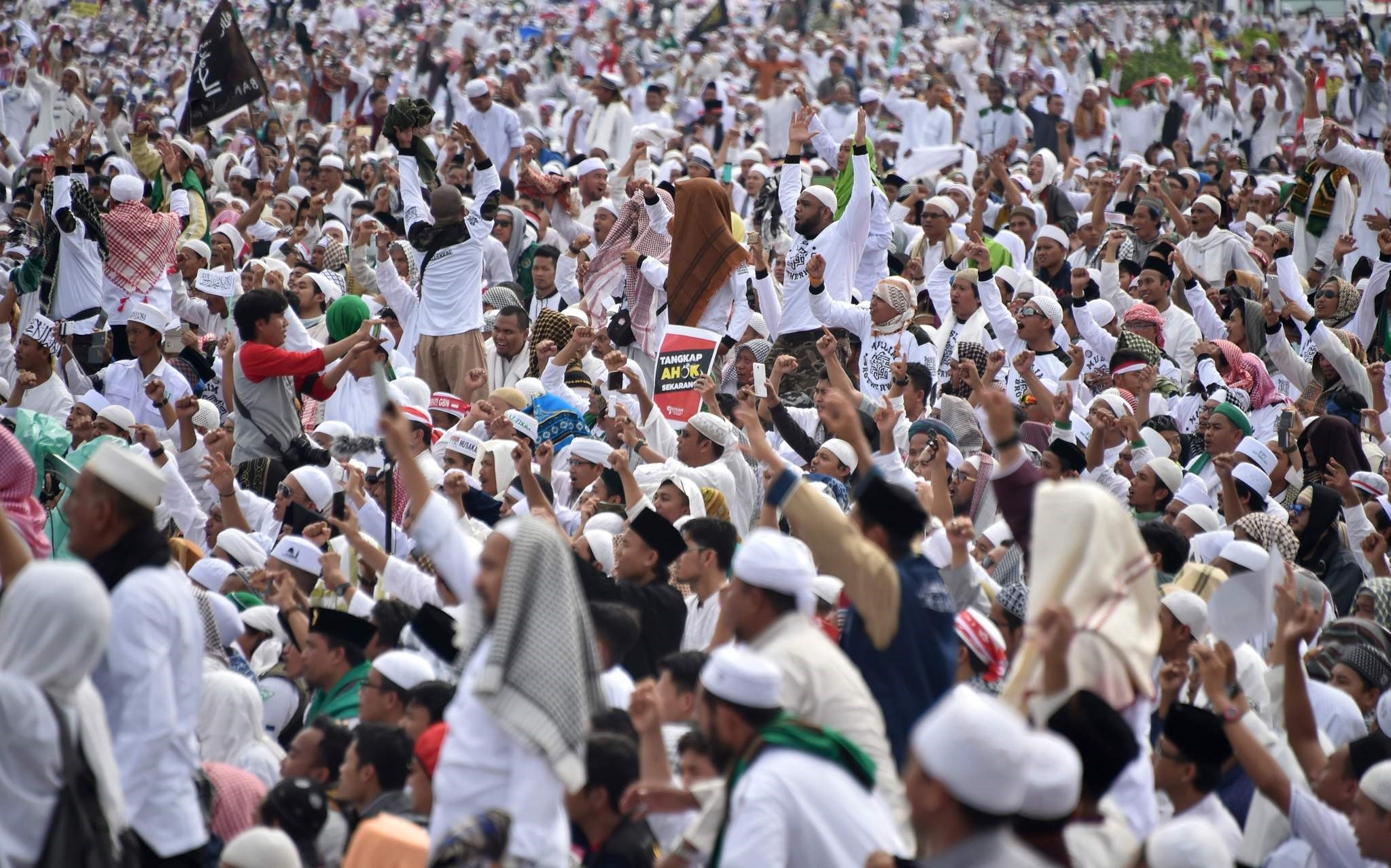 Indonesian Muslims gather in the rain at Jakartau2019s National Monument Park as part of a rally against Jakarta's Governor Basuki Tjahaja Purnama, Dec. 2, 2016. (AFP Photo)