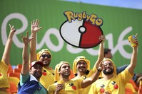 Rugby fans dressed as Pikachu from u201cPokemon Gou201d watch from the stands.