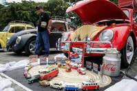 A man walks along different Volkswagen Beetles and collectible toys during the World Volkswagen Day in Quezon city, east of Manila, Philippines.