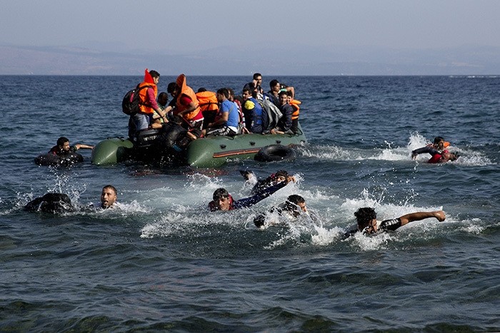 Refugees whose boat stalled at sea while crossing from Turkey to Greece swim to approach the shore of the island of Lesbos, Greece, on Sunday, Sept. 20, 2015.