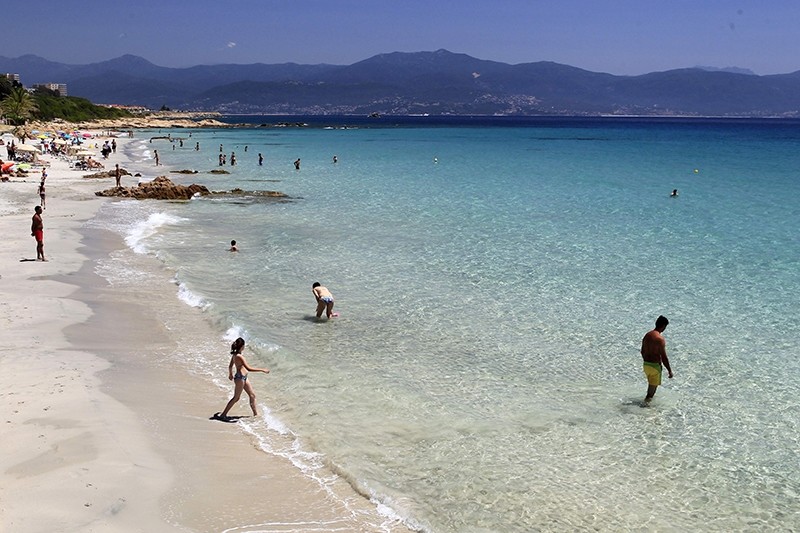 People stand on the beach in Ajaccio on June 25, 2016 on the French island of Corsica. (AFP PHOTO)