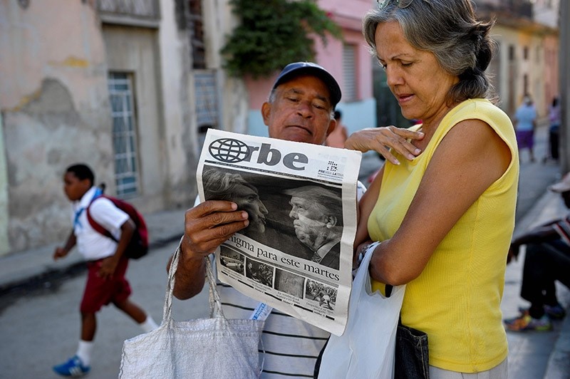 Cubans read a newspaper with its front page informing of the victory of US presidential candidate Donal Trump in a street of Havana, on November 9, 2016. (Photo AFP)