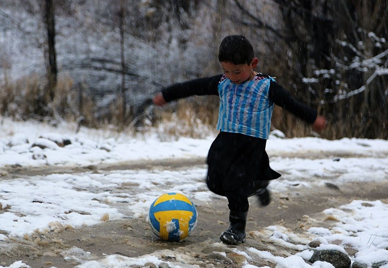 Afghan boy and Lionel Messi fan Murtaza Ahmadi, 5, wears a plastic bag jersey as he plays football in Jaghori district of Ghazni province. (AFP Photo)