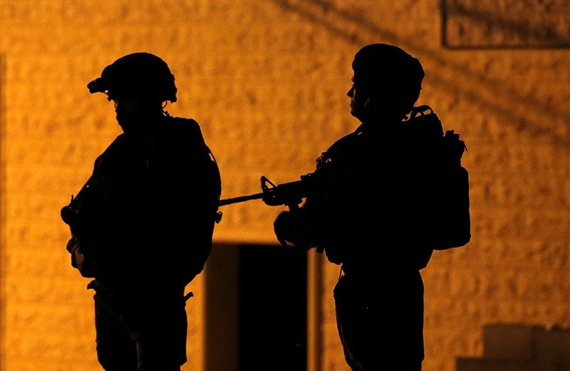 Israeli army soldiers are seen during a night raid as they purportedly arrested Palestinian Abed Abu Eram, in Yatta, south of the city of Hebron, The West Bank, 15 June 2016. (EPA)