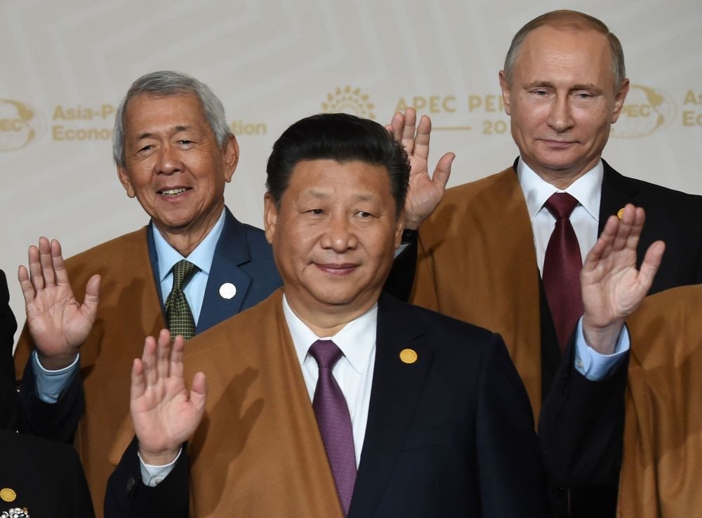 (L to R) Philippine Foreign Secretary Perfecto Yasay, Chinau2019s Xi Jinping and Russiau2019s Putin take part in the traditional u201cfamily photou201d on the final day of the Asia-Pacific Economic Cooperation Summit at the Lima Convention Centre in Lima.