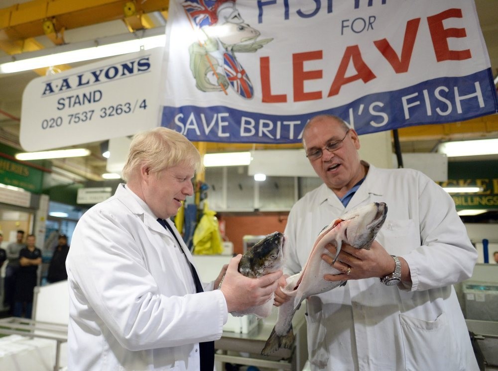 Former London Mayor Boris Johnson (L) with a worker as he visits Billingsgate Market, Britain's largest wholesale fish market, during a campaign event in London on Wednesday.