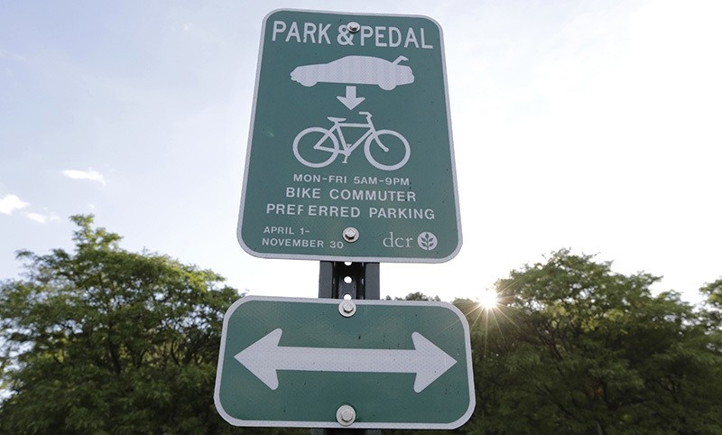 In this Thursday, June 23, 2016 photo a Park & Pedal sign stands at the edge of a parking lot, in Boston (AP Photo)
