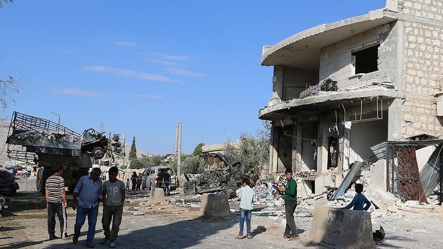 Syrian civilians walk in an area hit by Russian air strikes on Saturday, October 15, 2016. (AA Photo)