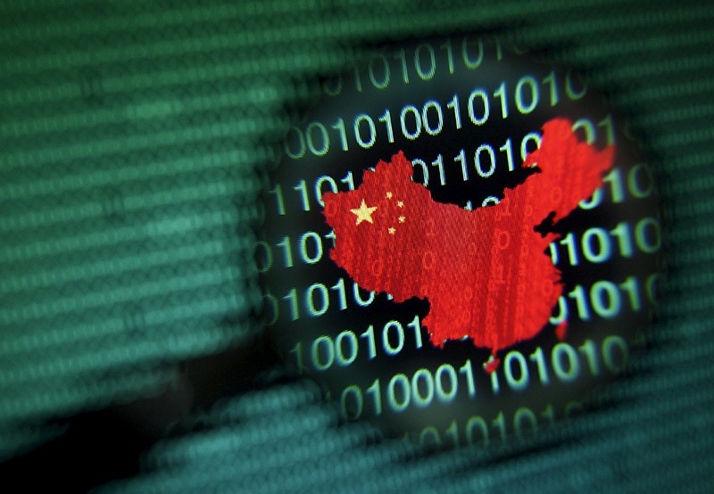 A logo shaped in the outline of China, is seen through a magnifying glass on a computer screen showing binary digits in Singapore. (Reuters File Photo)