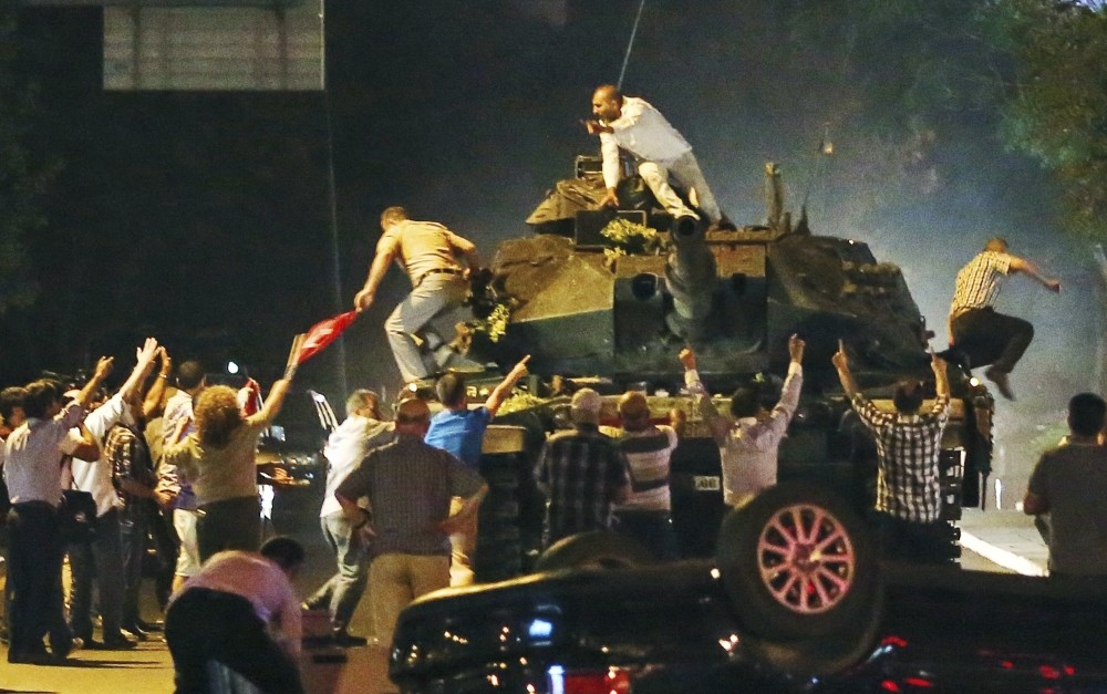 A tank moving into position as Turkish people clamber onto it, attempting to stop the Gu00fclenist military coup, in Ankara, July 16.