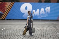 A worker walks past a poster reading ,May 9 Victory, installed for Victory Day celebrations in Red Square in Moscow, Russia, Friday, May 6, 2016 (AP Photo)