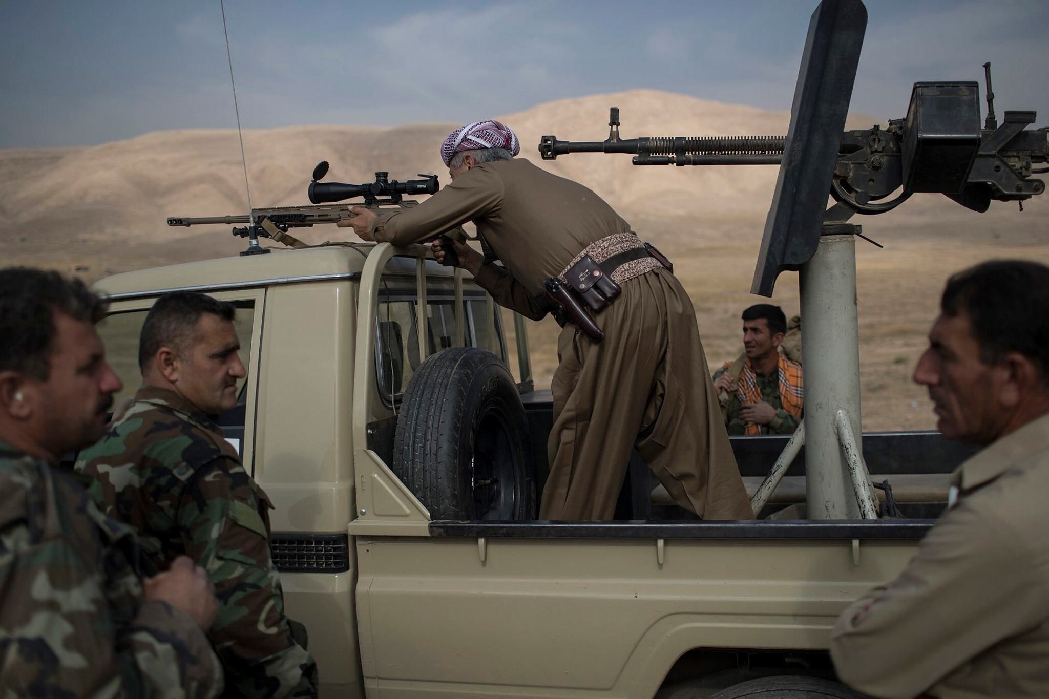 Kurdish Peshmerga fighter looks at Daesh militant positions during heavy fighting in Bashiqa, east of Mosul, Iraq. (AP Photo)
