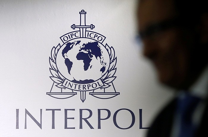 A man passes an Interpol logo during the handing over ceremony of the new premises for Interpol's Global Complex for Innovation, a research and development facility, in Singapore September 30, 2014. (Reuters Photo)