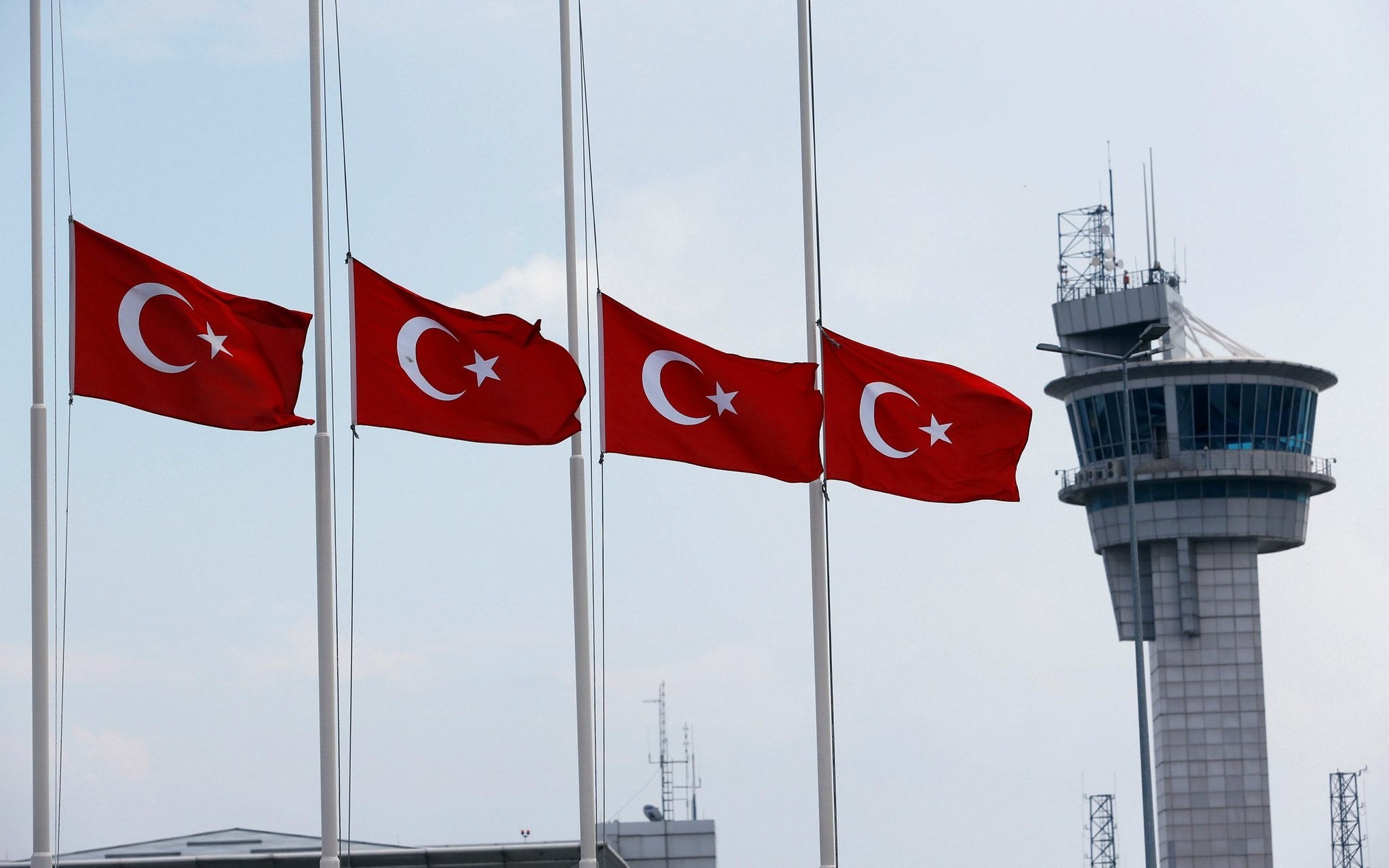Turkish flags, with the control tower in the background, fly at half mast at the country's largest airport, Istanbul Atatu00fcrk, following the June attack there. (Reuters Photo)