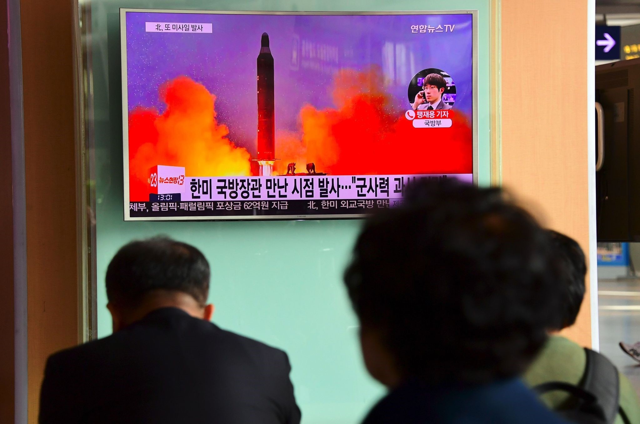 People watch a television news report showing file footage of North Korea's missile launch at a railway station in Seoul on October 20, 2016. (AFP Photo)
