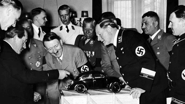 Adolf Hitler and his officials inspect a Volkswagen Beetle model