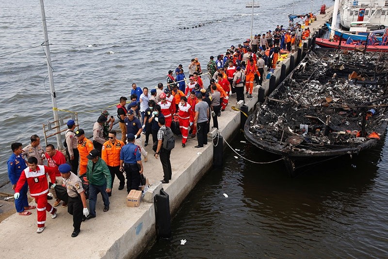 Security forces, Red Cross and rescue workers carry body bags with the remains of victims after a fire ripped through a boat carrying tourists. (Reuters Photo)