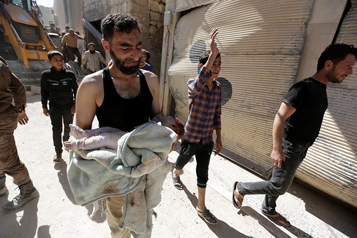 A civil defence member mourns as he carries the body of a dead child at a site hit by airstrike in the rebel-controlled area of Maaret al-Numan town in Idlib province, Syria, June 12, 2016. (Reuters Photo)