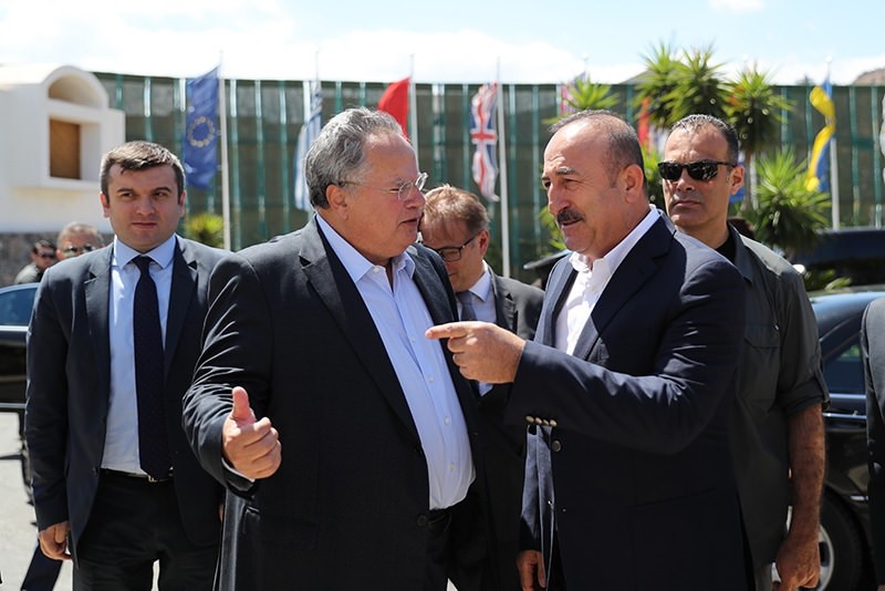 Turkish FM Mevlu00fct u00c7avuu015fou011flu (R) was greeted by his Greek counterpart Nikos Kocias at the entrance of the hotel in the town of Elounda. (AA Photo)