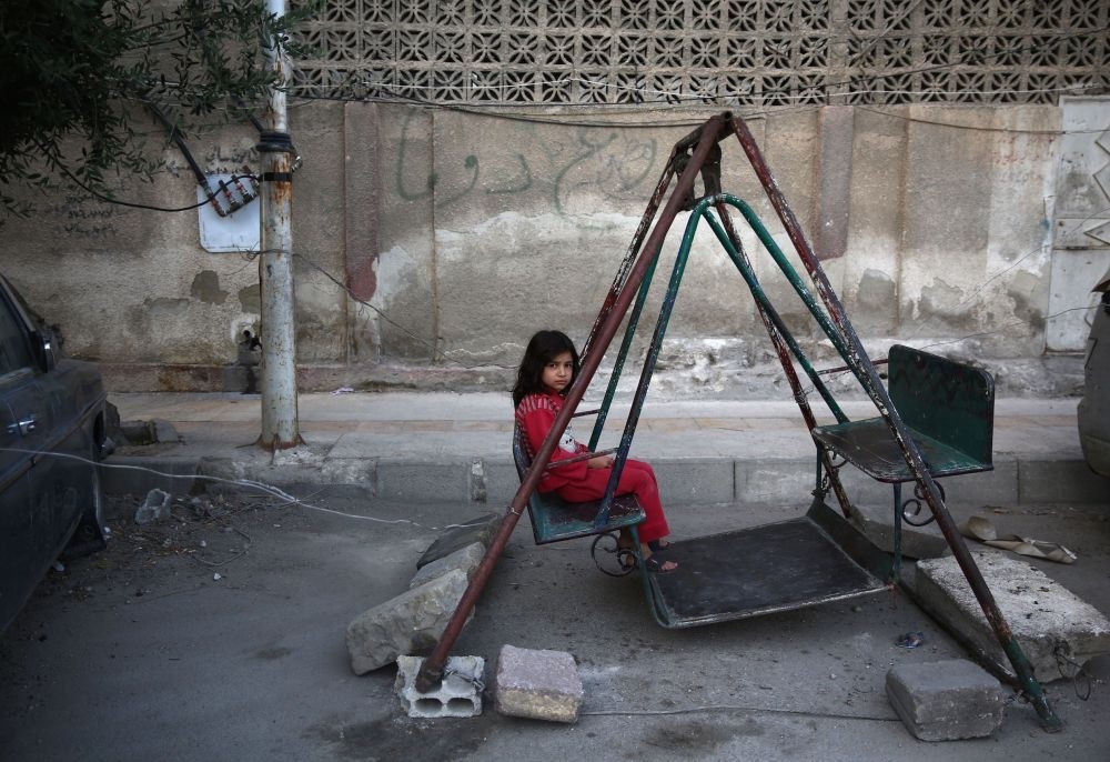 A Syrian girl playing on a swing in the moderate-held town of Douma, east of capital Damascus on the first day of Ramadan Bayram holiday that marks the end of the Muslim holy fasting month of Ramadan July 6, 2016. (AFP Photo)