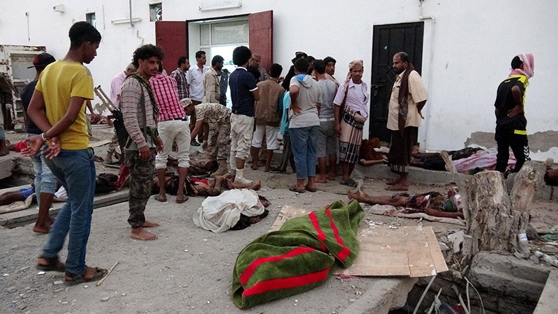 Soldiers and people gather by the bodies of soldiers killed by a suicide bomber at a base in the southern port city of Aden, Yemen on Dec. 10, 2016. (Reuters Photo)