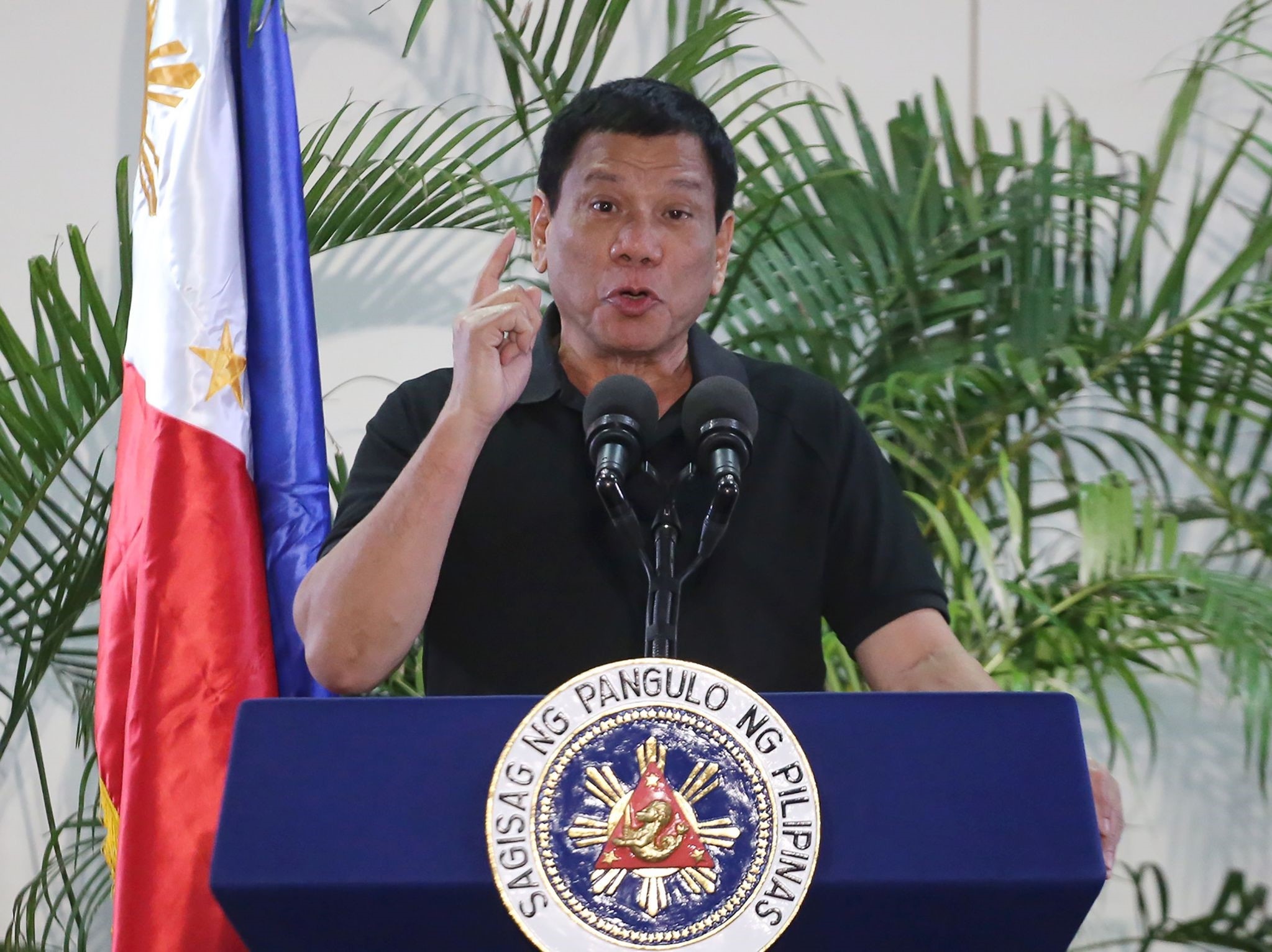 Philippines President Rodrigo Duterte delivers a speech at the Davao international airport terminal building early on September 30, 2016, shortly after arriving from an official visit to Vietnam. (AFP Photo)