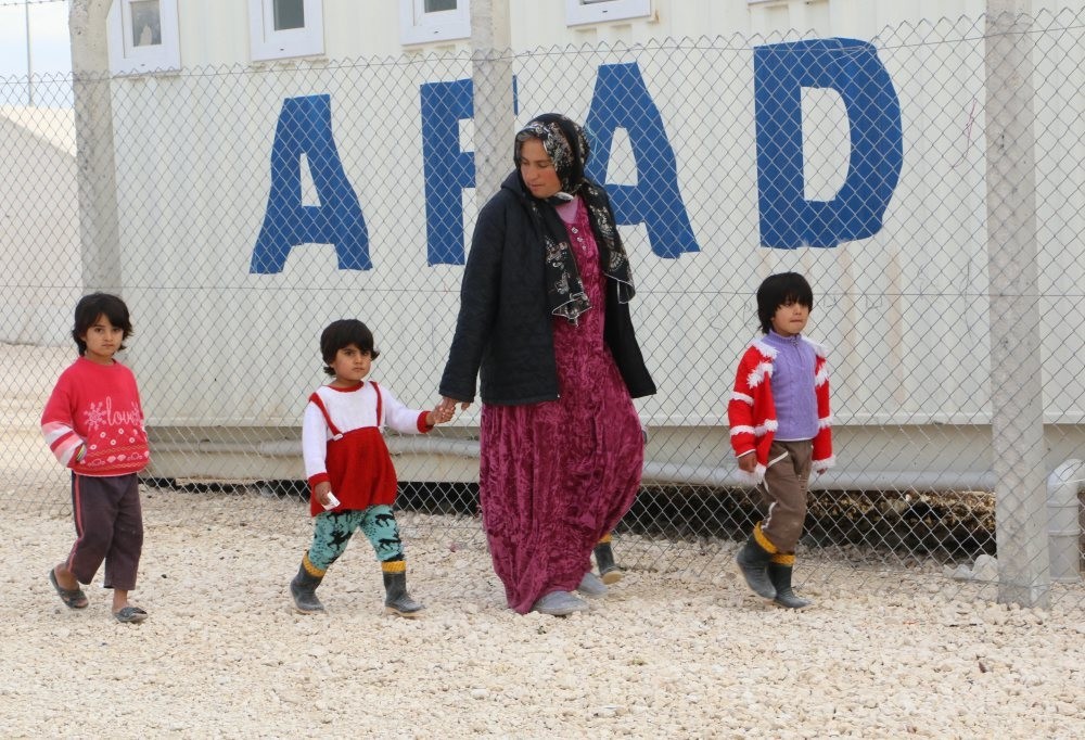 A Syrian refugee woman walks with children at a refugee camp in u015eanlu0131urfa. Women and children make up three quarters of the refugee population according to UNHCR.