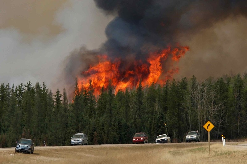 A wildfire burns as evacuees who were stranded north of Fort McMurray, Alberta, Canada head south of Fort McMurray on Highway 63, May 6, 2016. (REUTERS Photo)