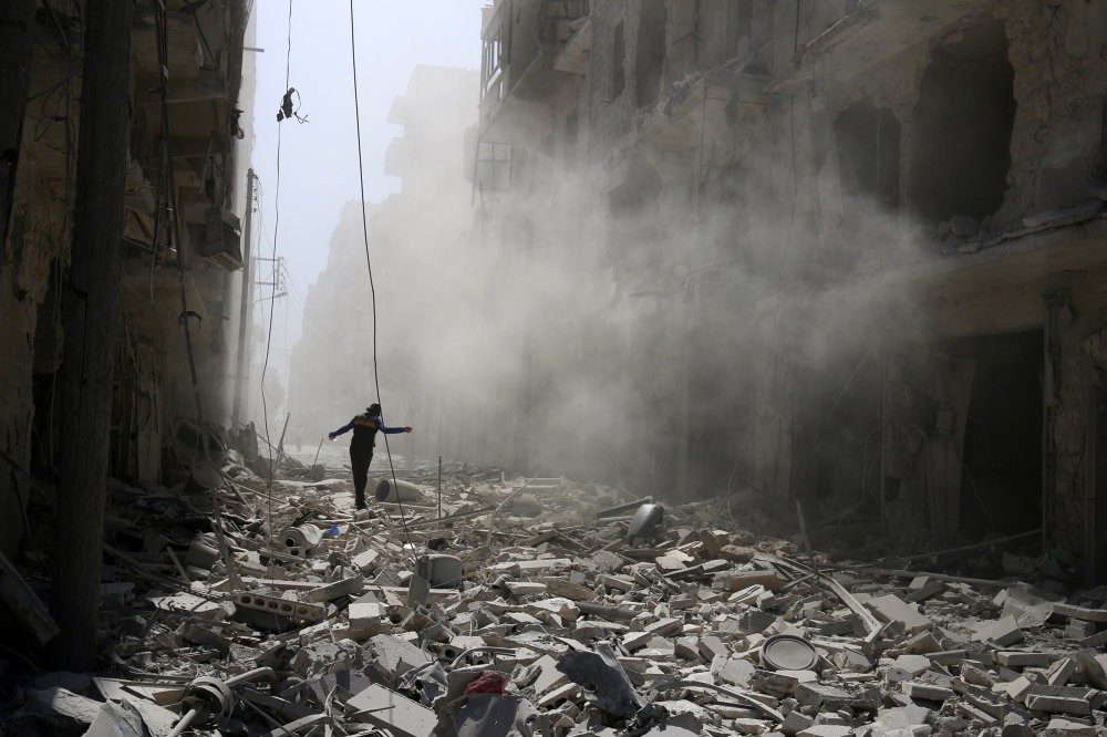 A man walking on the rubble of damaged buildings after an airstrike on the moderate-held al-Qaterji neighborhood of Aleppo, Syria, Sept. 25, 2016.