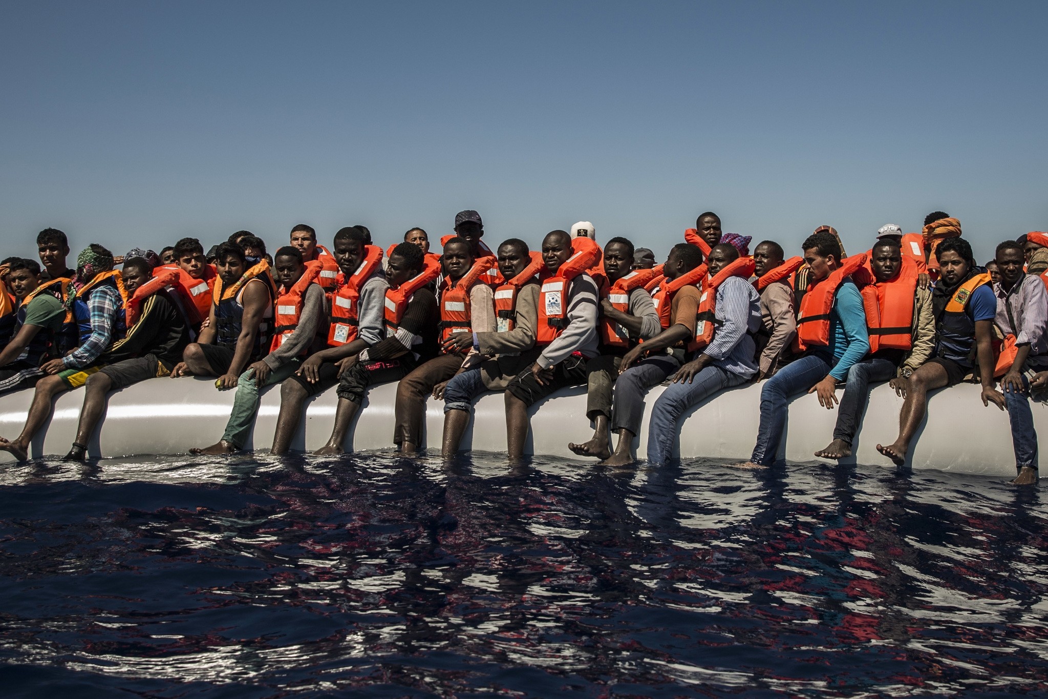 In this Tuesday July 19, 2016 photo, refugees and migrants from Eritrea, Mali, Bangladesh and other countries wait on board a dinghy to be rescued in the Mediterranean Sea, 27 kilometers (17 miles) north of Sabratha, Libya. (AP Photo)