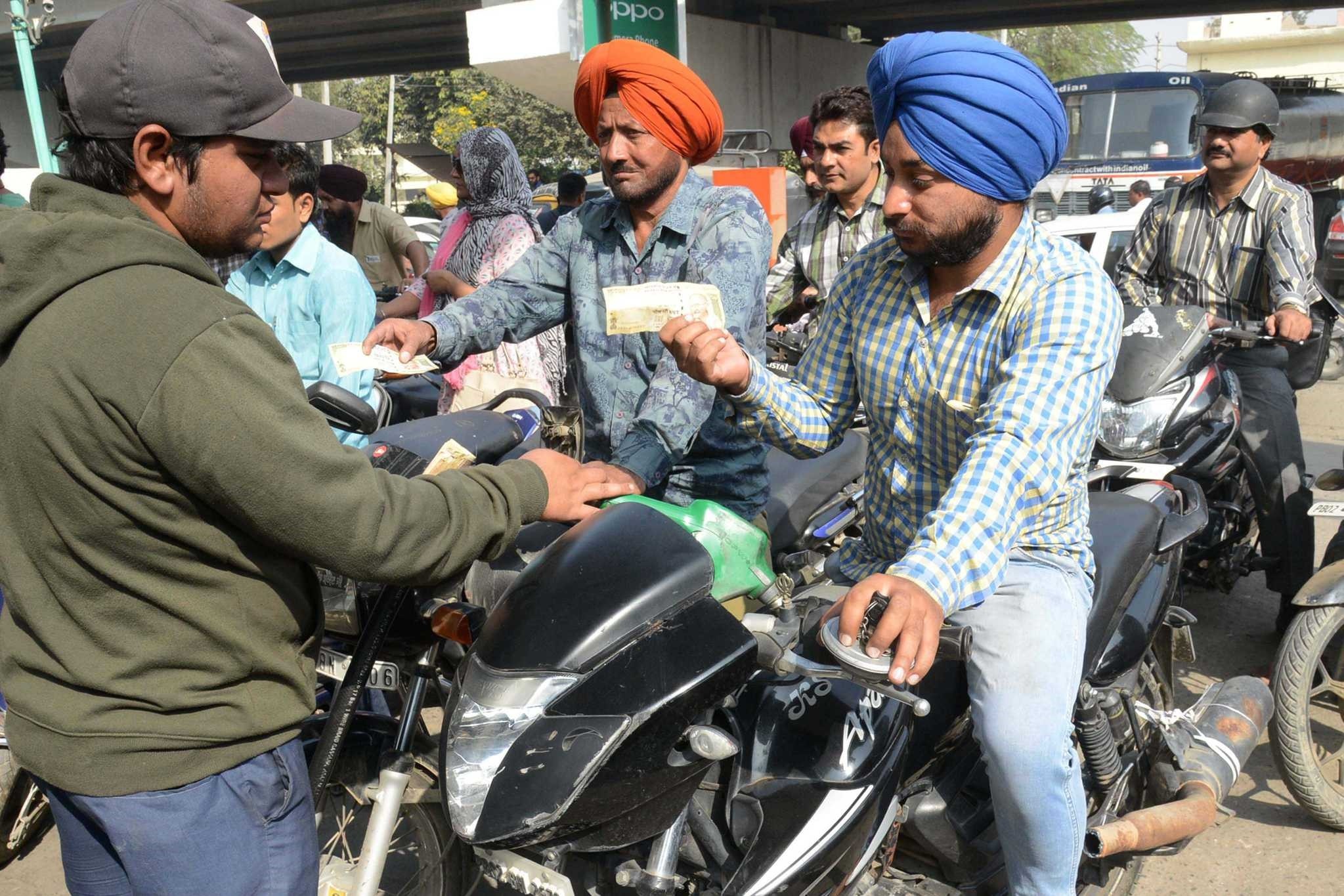 Indian motorists pay with 500 rupee notes at a fuel station in Amritsar. ATMs were closed and many are likely to remain shut today as banks prepare for the flood of people seeking to exchange larger banknotes.