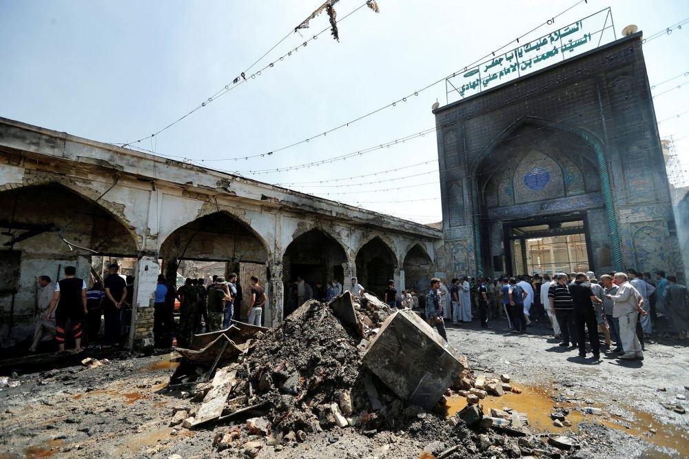 People gather at the site of a suicide bombing at the entrance of Mausoleum of the Sayid Mohammed bin Ali al-Hadi in Balad, north of Baghdad. (Reuters Photo)