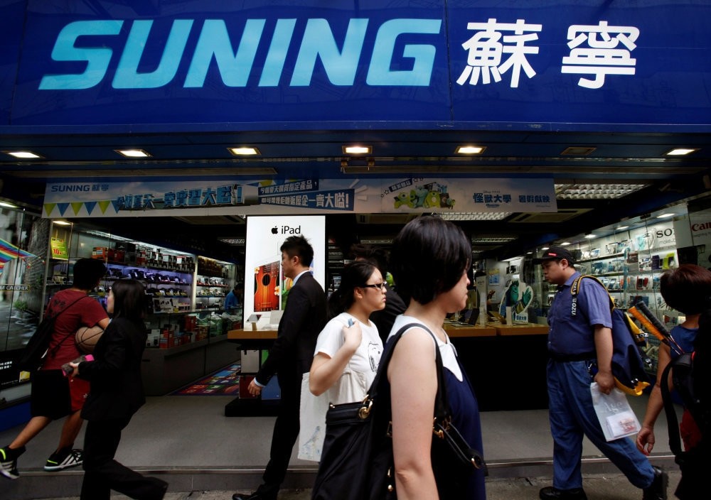 People walk past a Suning store, one of the largest home appliance retailers in Hong Kong.