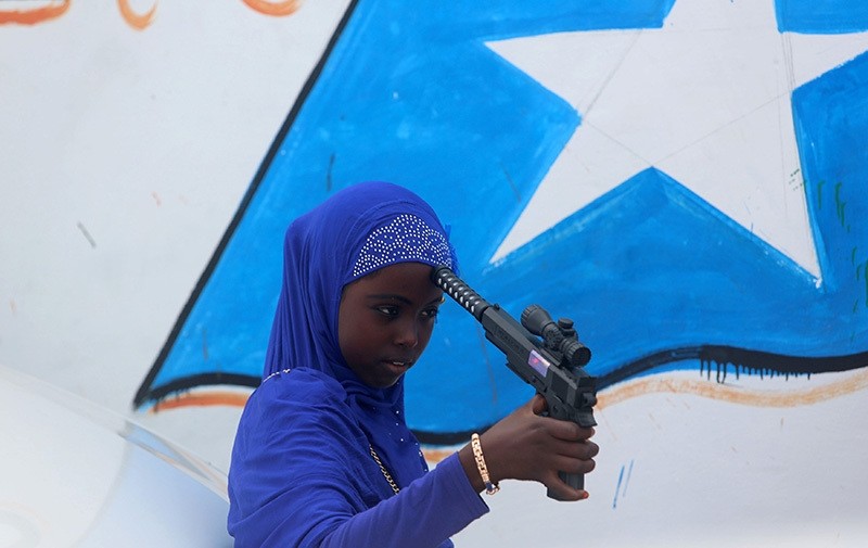 A Somali girl plays with a toy gun after attending Eid al-Fitr prayers to mark the end of the fasting month of Ramadan in Somalia's capital Mogadishu, July 6, 2016. (Reuters Photo)